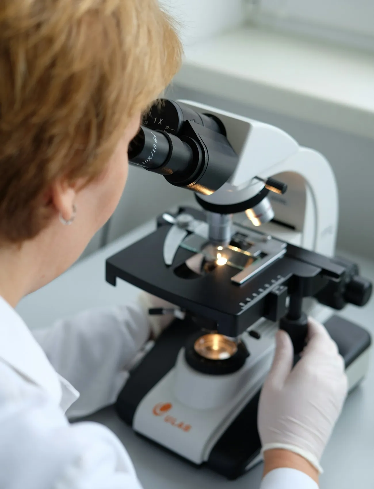 Patóloga observando una muestra en el microscopio